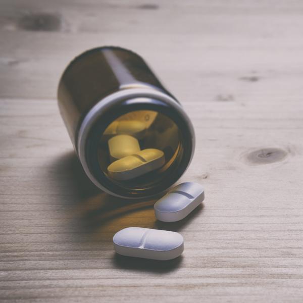 bottle of pills spilling on a table